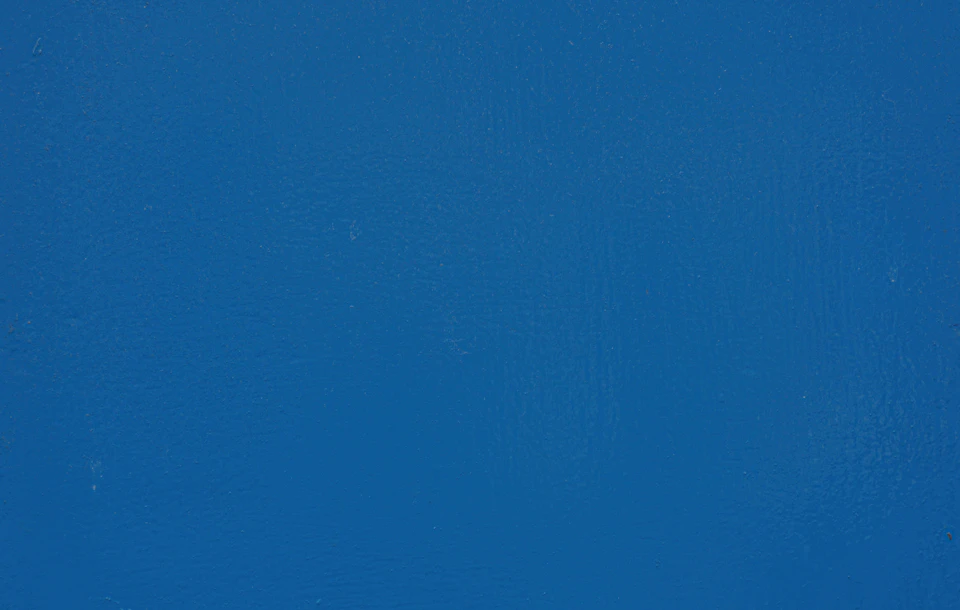 Close-up view of a blue wall with a gray border and textured surface