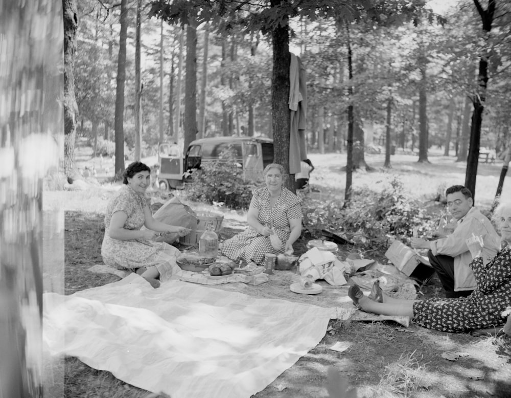 grayscale photo of people sitting on ground