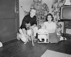 grayscale photo of boy sitting beside dog on floor