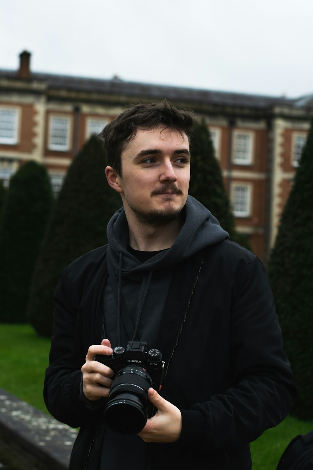 man in black hoodie holding black camera