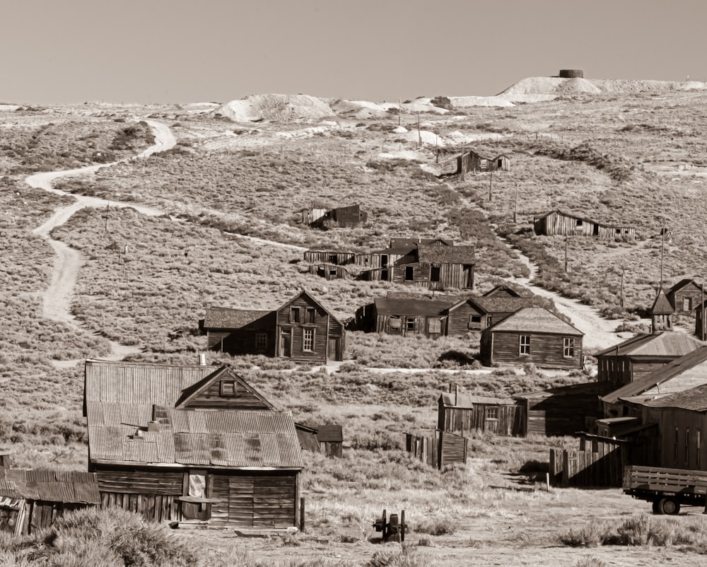 grayscale photo of wooden house on grass field