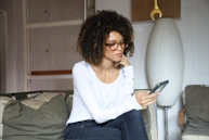 woman in white long sleeve shirt and blue denim jeans sitting on bed