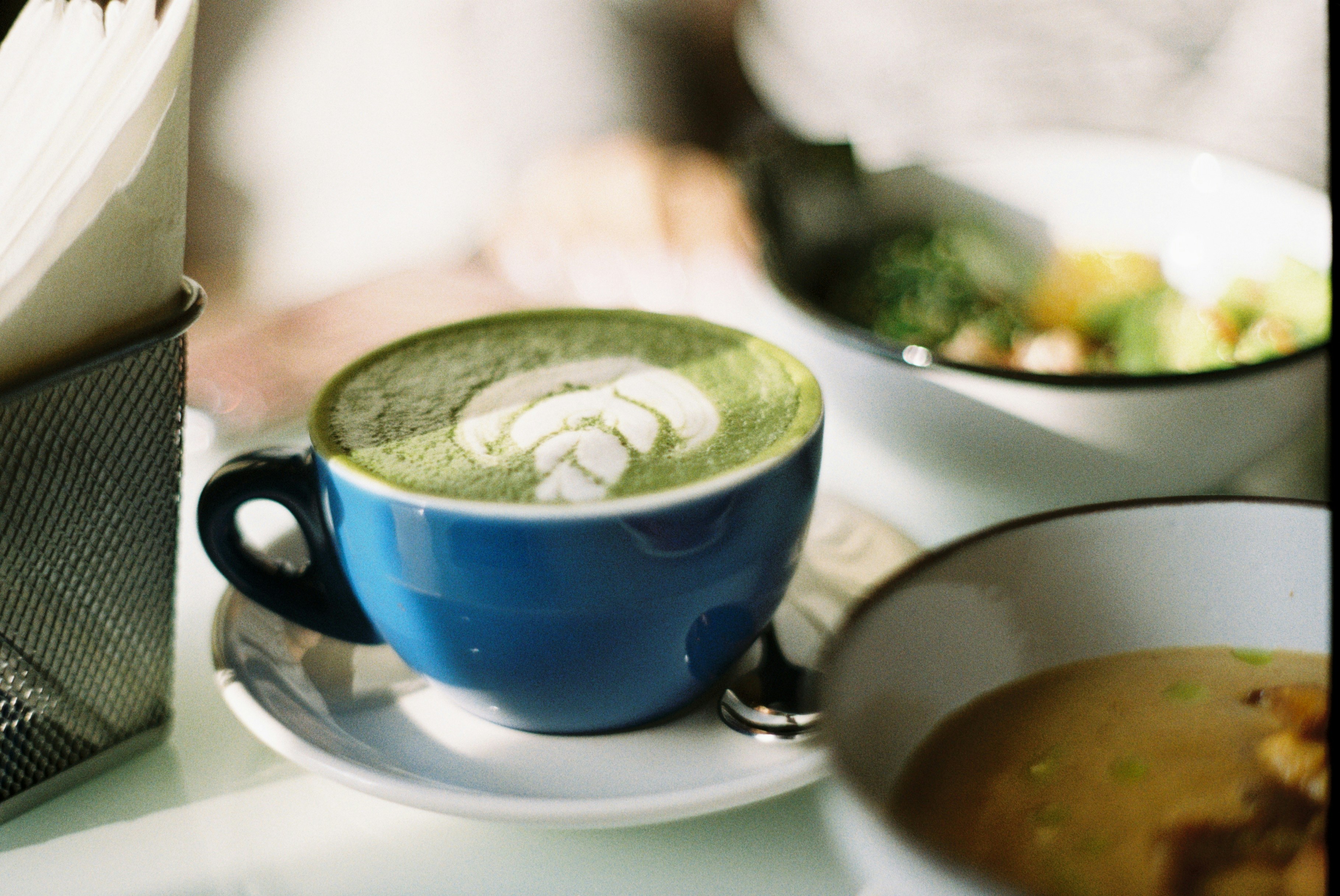синяя керамическая чашка с зелёной жидкостью внутри