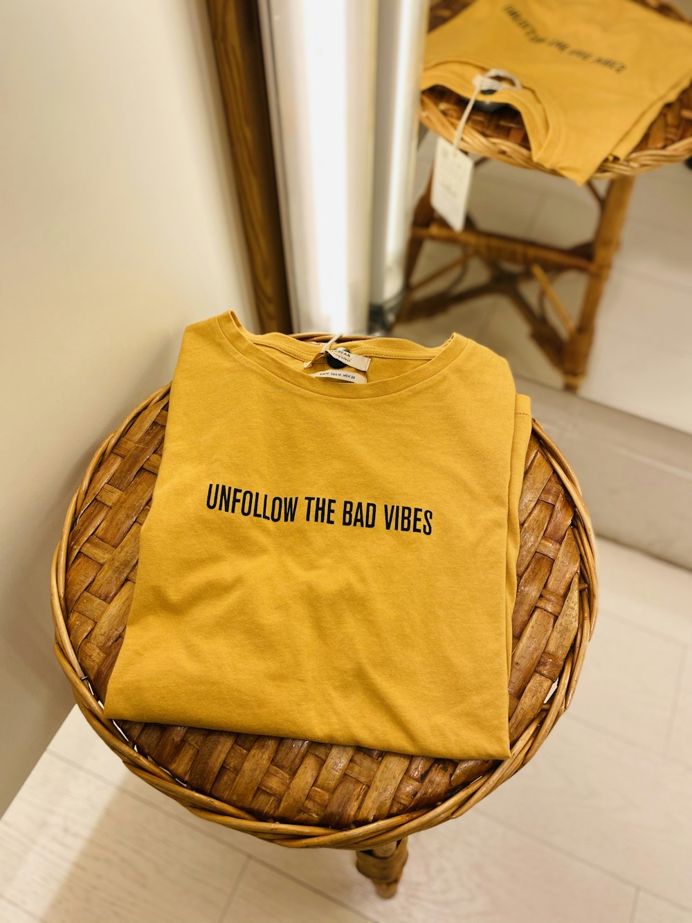 yellow and black crew neck shirt on brown woven chair