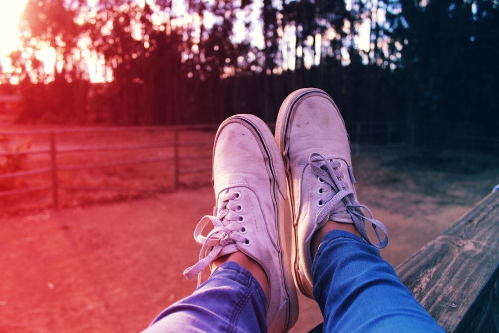 persona in jeans blu denim e scarpe da ginnastica bianche