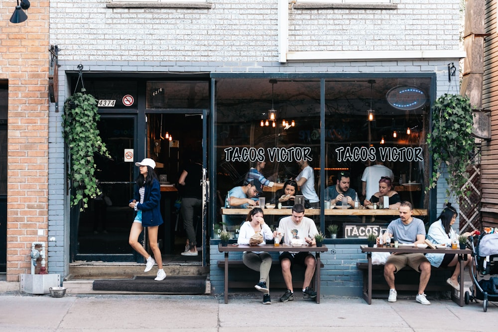 people sitting on bench in front of the coffee shop during daytime