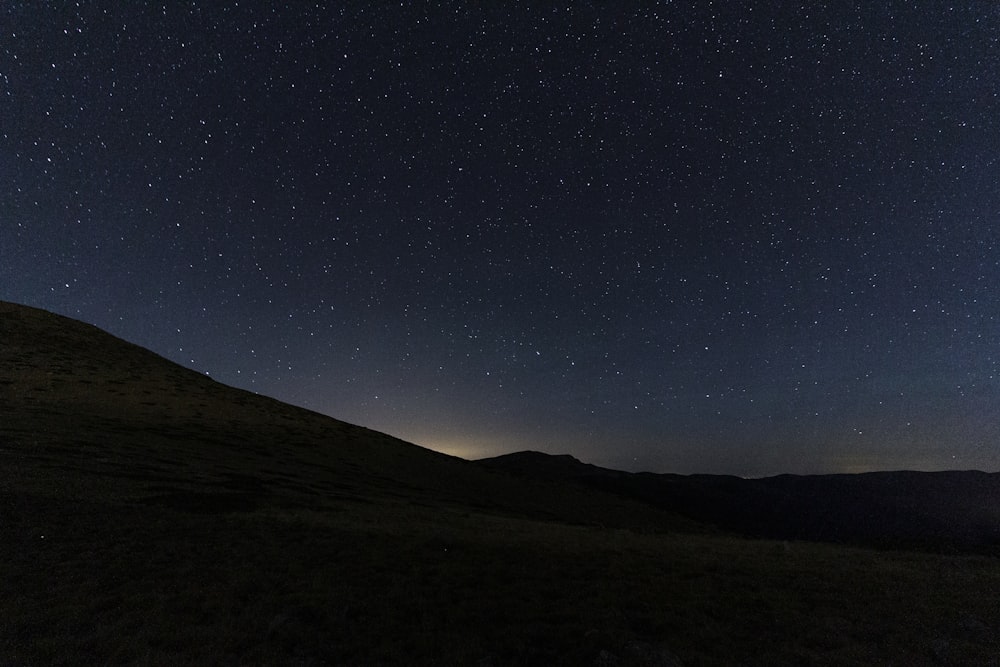 silhouette of mountain under blue sky during night time