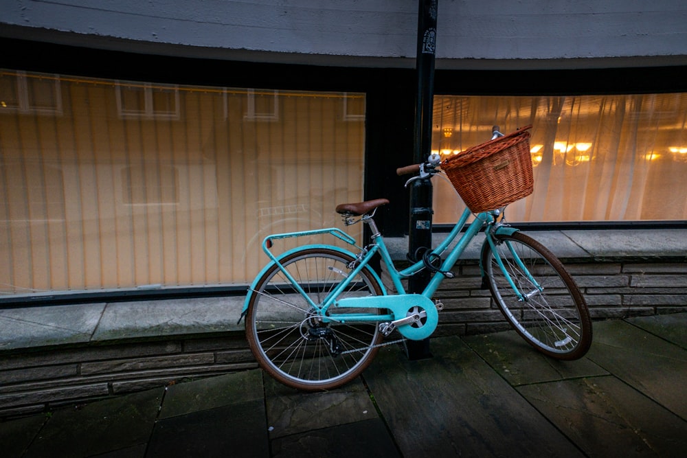 blue city bike parked beside brown wooden wall