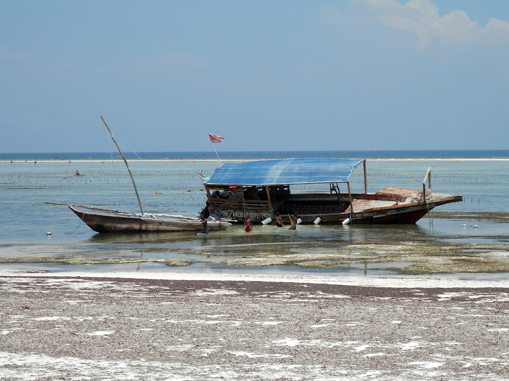 bateau brun et blanc sur le bord de la mer pendant la journée