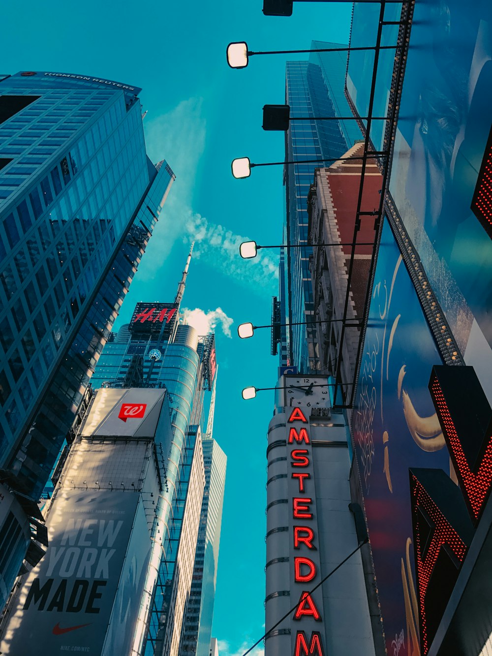 cars on road in between high rise buildings during night time