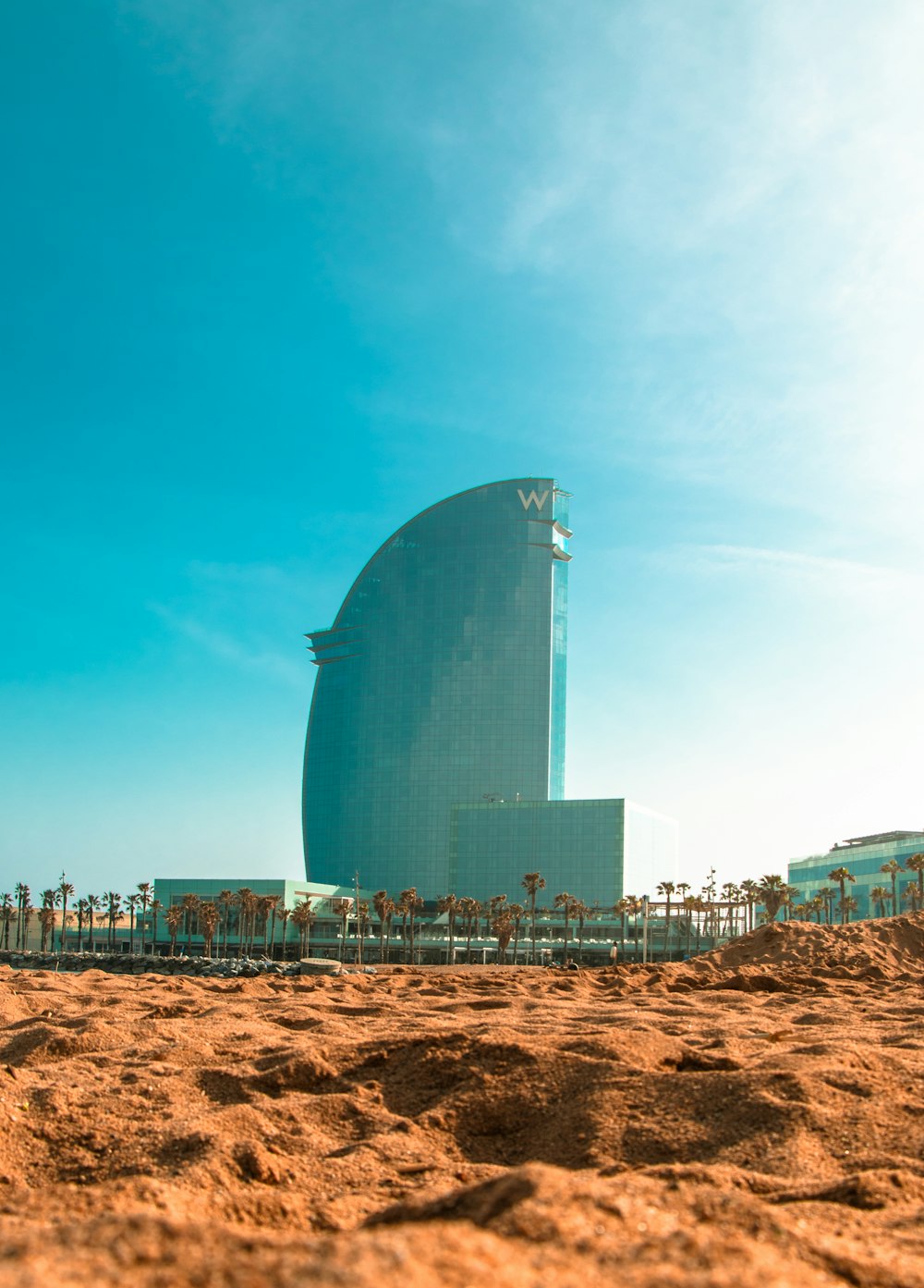 edificio di vetro blu vicino all'edificio bianco durante il giorno