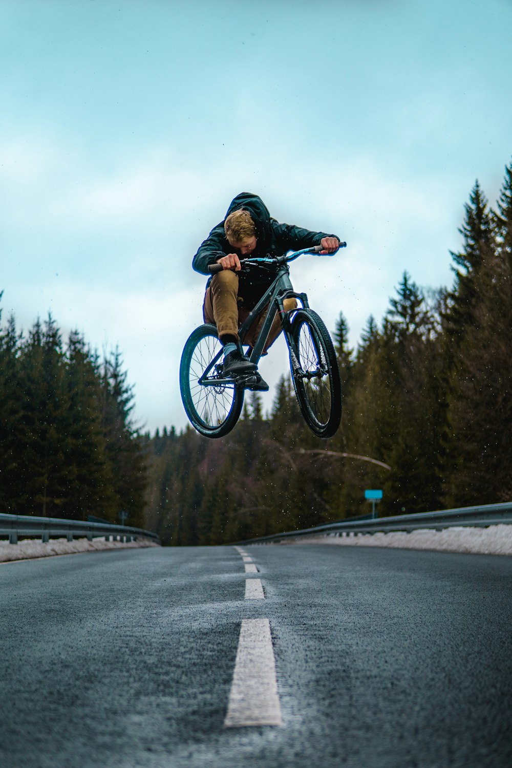 man riding on black mountain bike on road during daytime