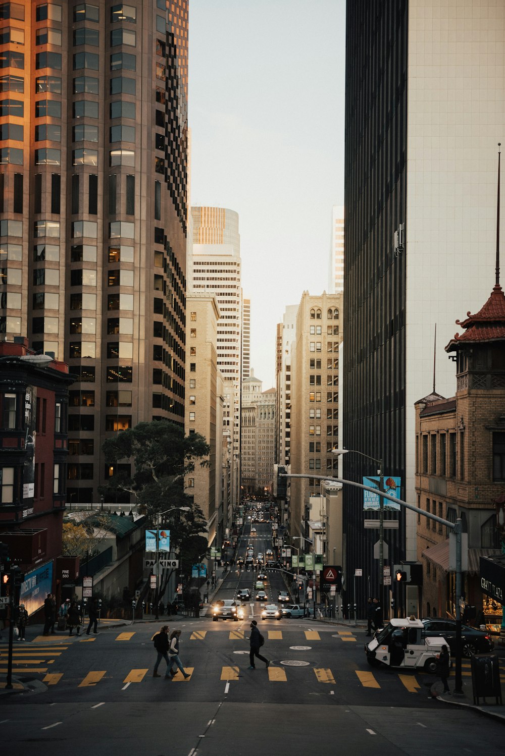 cars on road between high rise buildings during daytime