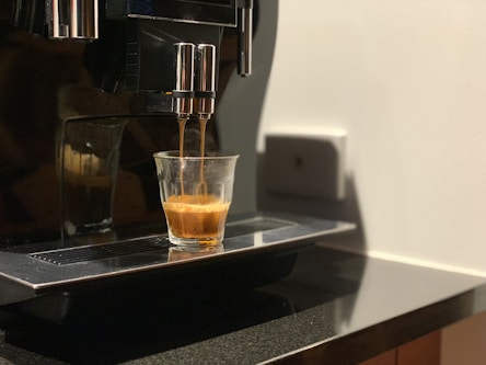 clear drinking glass on black and silver coffee maker