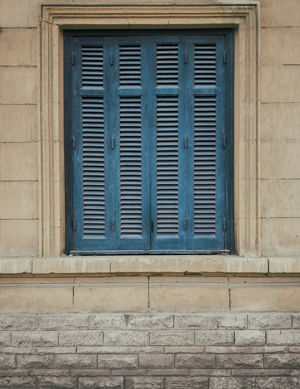 blue wooden window on gray concrete wall