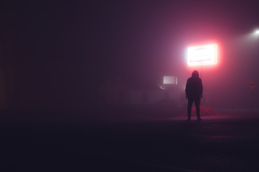 Silhouette eines Mannes, der nachts auf dem Feld steht