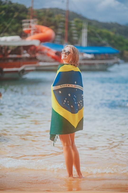 woman in blue and yellow dress standing on beach during daytime in Brazil Brasil