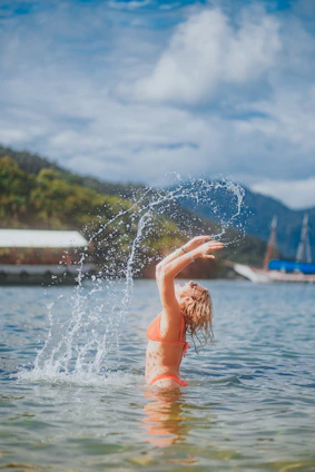 woman in red bikini on water fountain during daytime