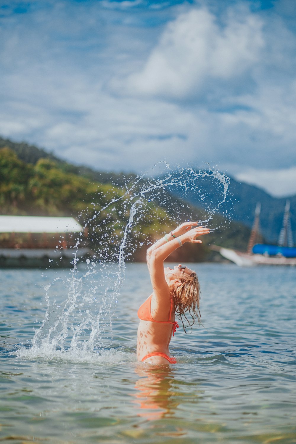 woman in red bikini on water fountain during daytime