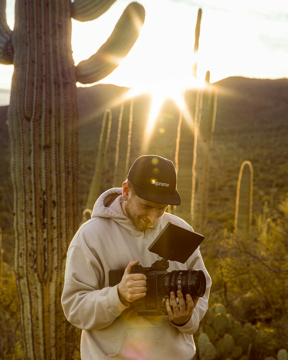 man in gray hoodie holding black ceramic mug