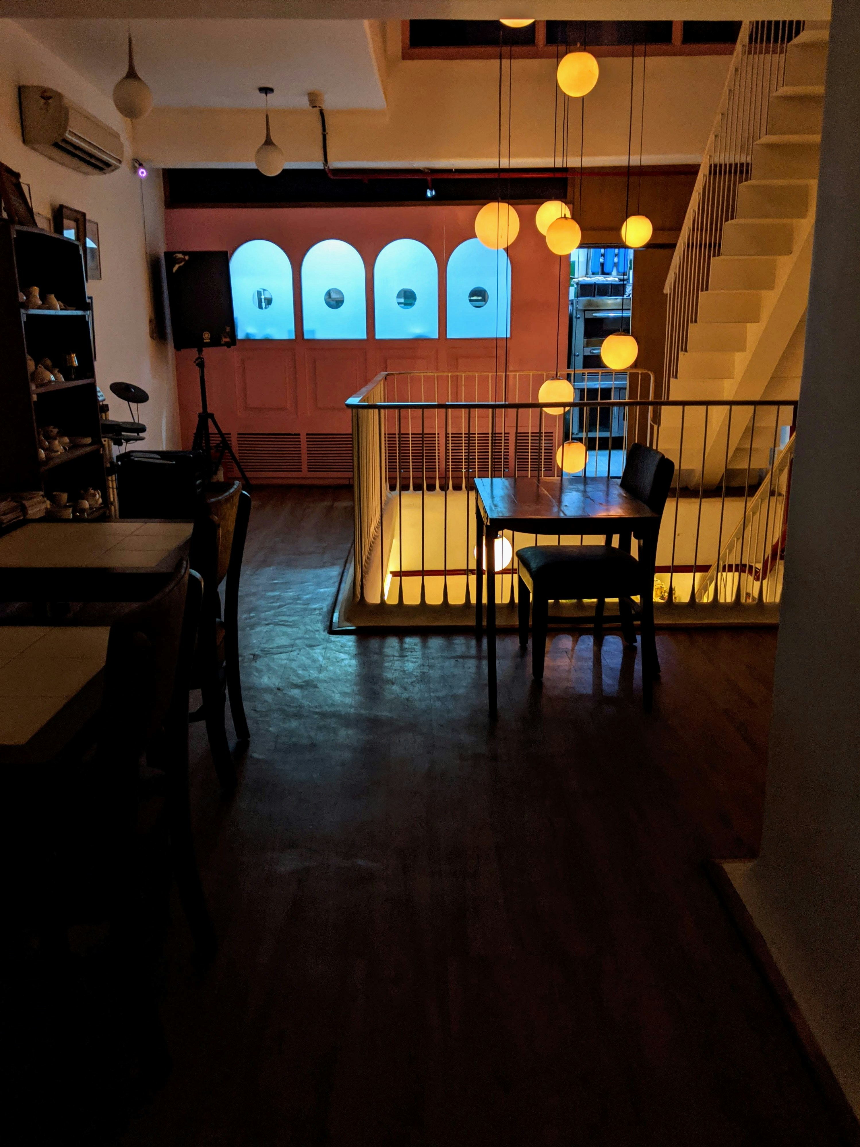 man in black shirt standing near brown wooden table