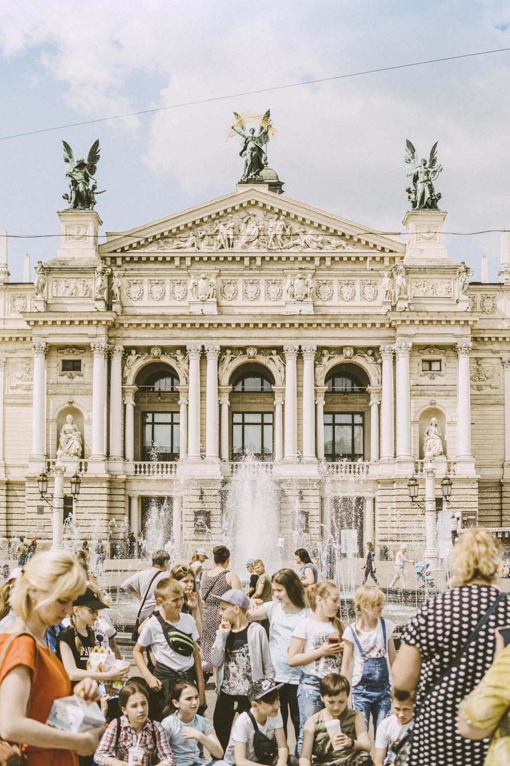 people sitting on chair near fountain during daytime