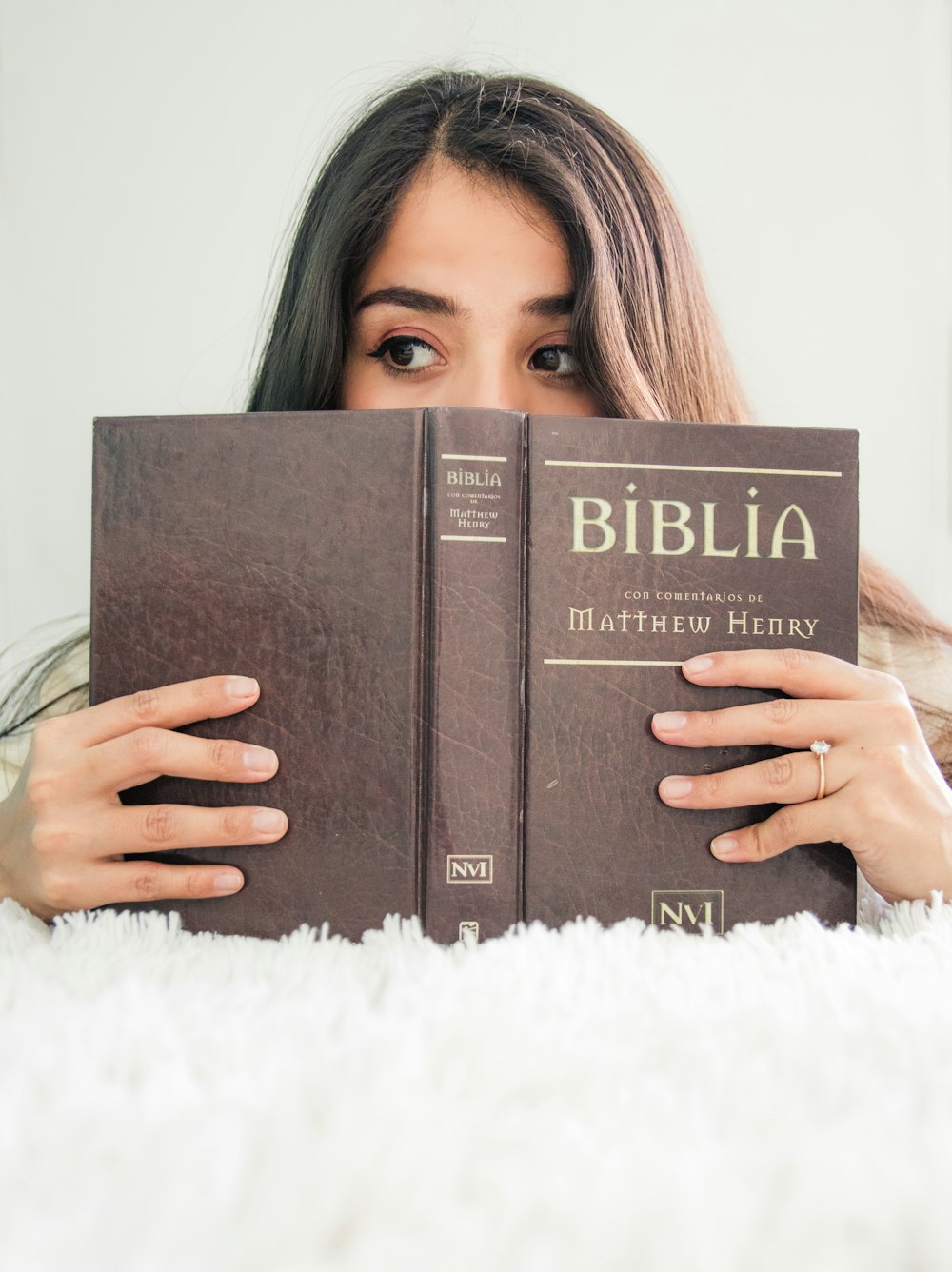 woman covering her face with book