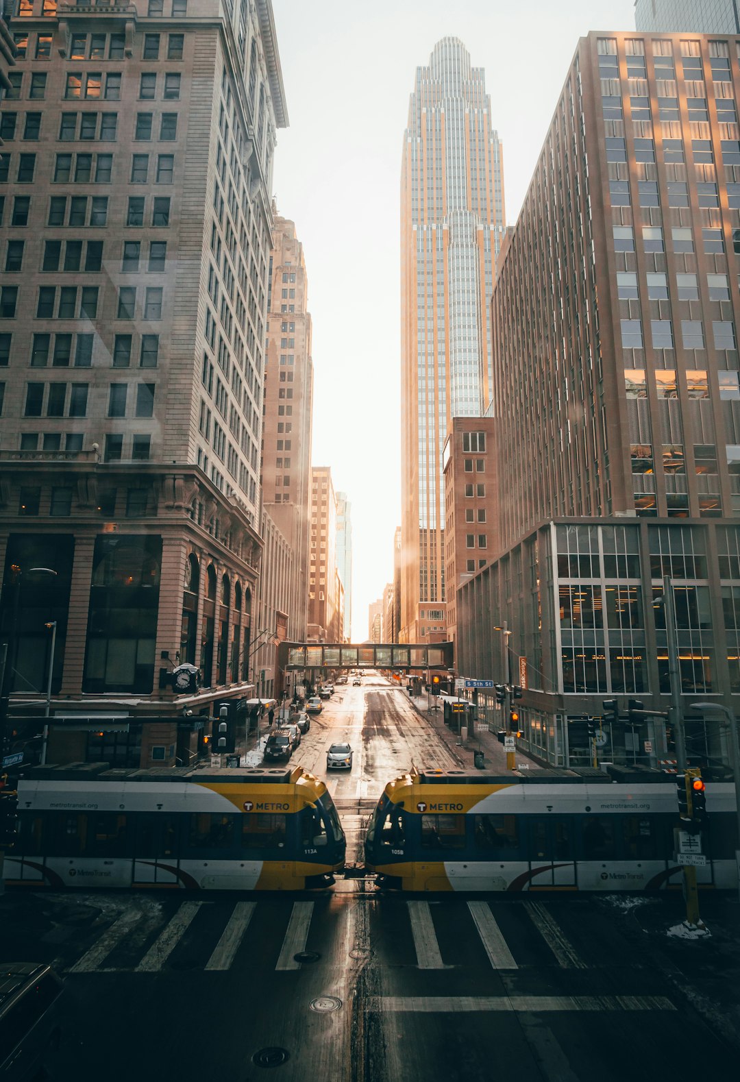 cars on road in between high rise buildings during daytime