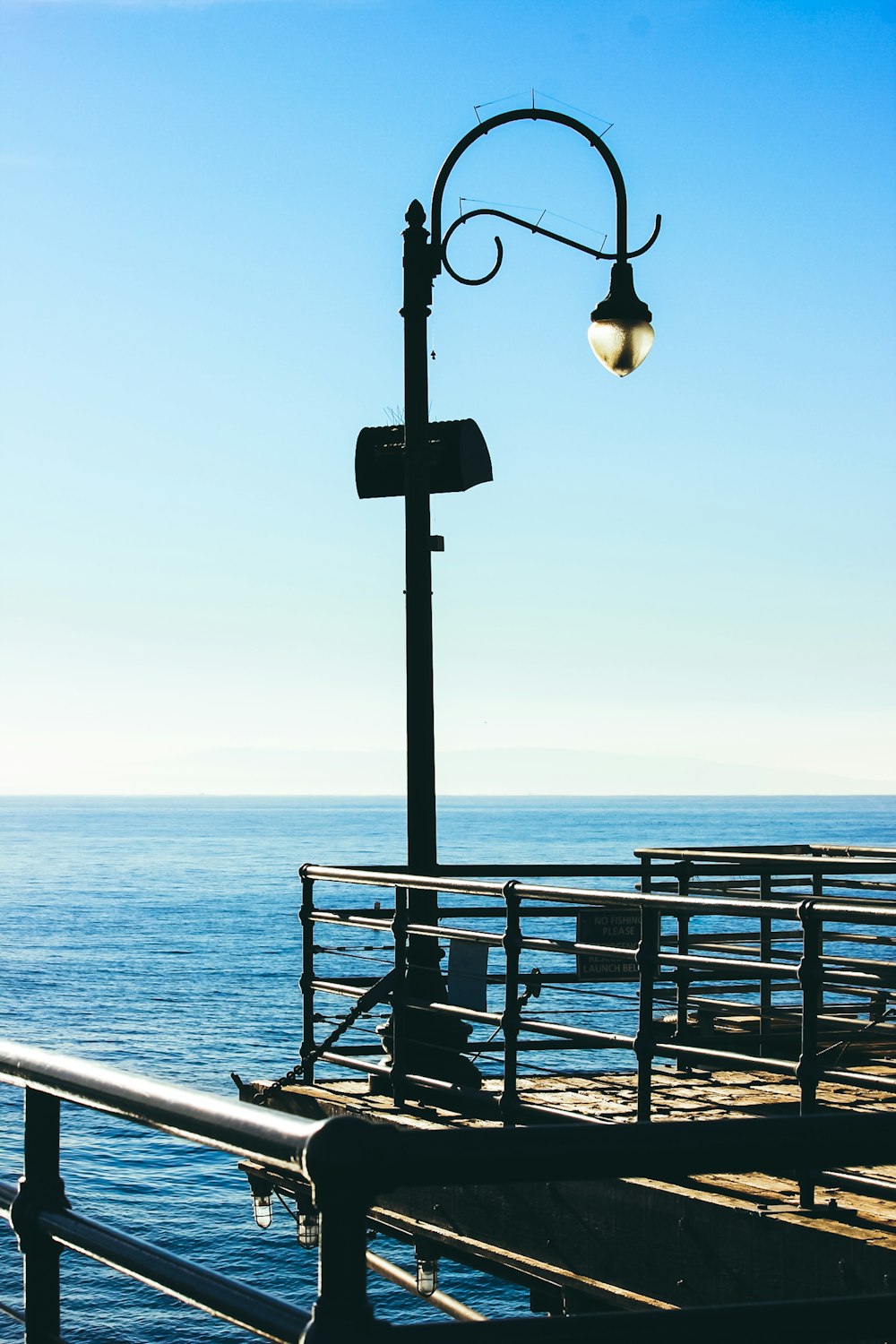 black metal light post near sea during daytime