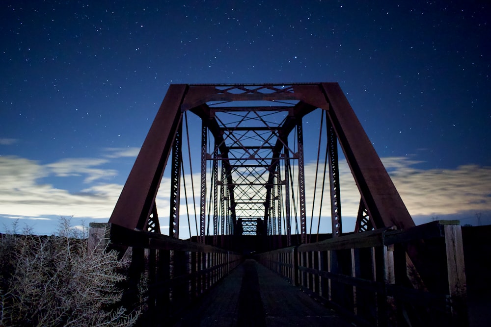 Puente de metal gris bajo el cielo azul durante la noche