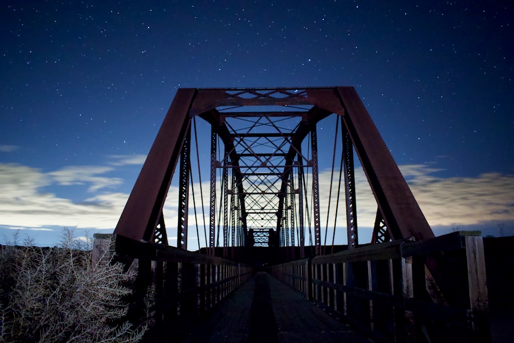 gray metal bridge under blue sky during night time
