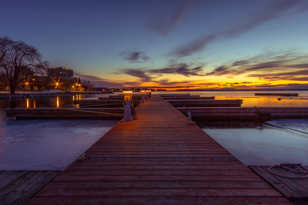 brown wooden dock during sunset