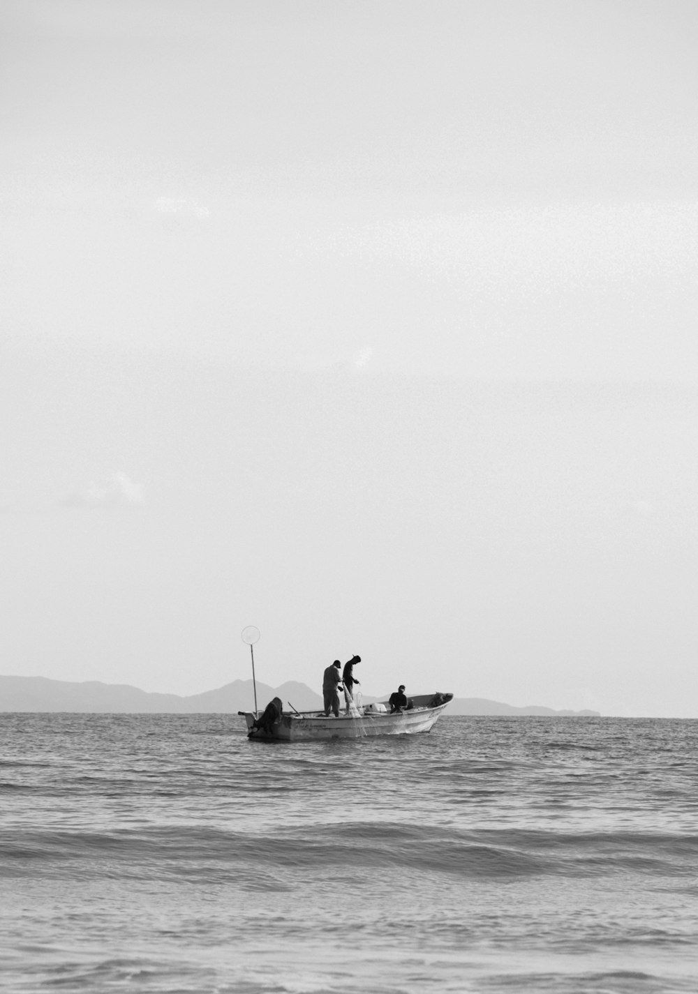 2 men riding on boat in grayscale photography