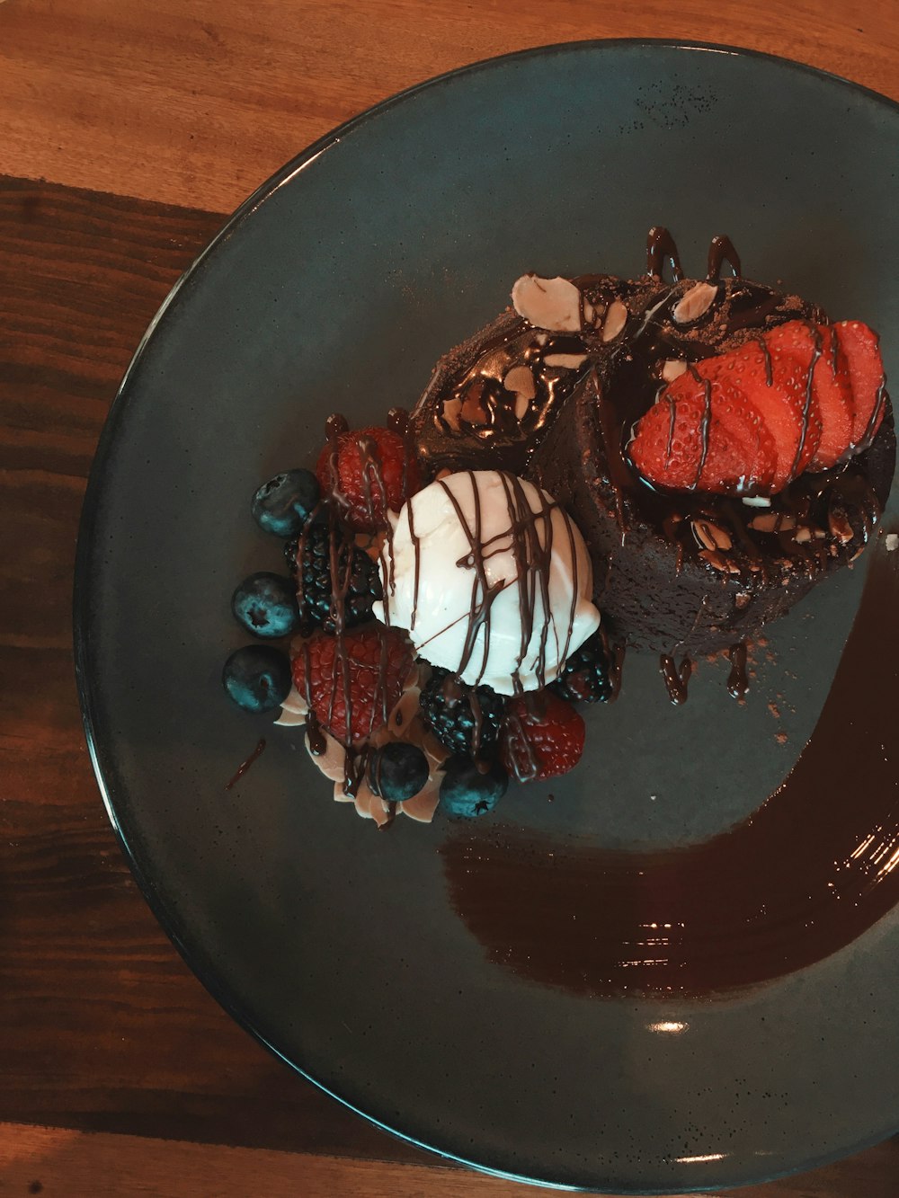 chocolate cake with white icing on black ceramic plate