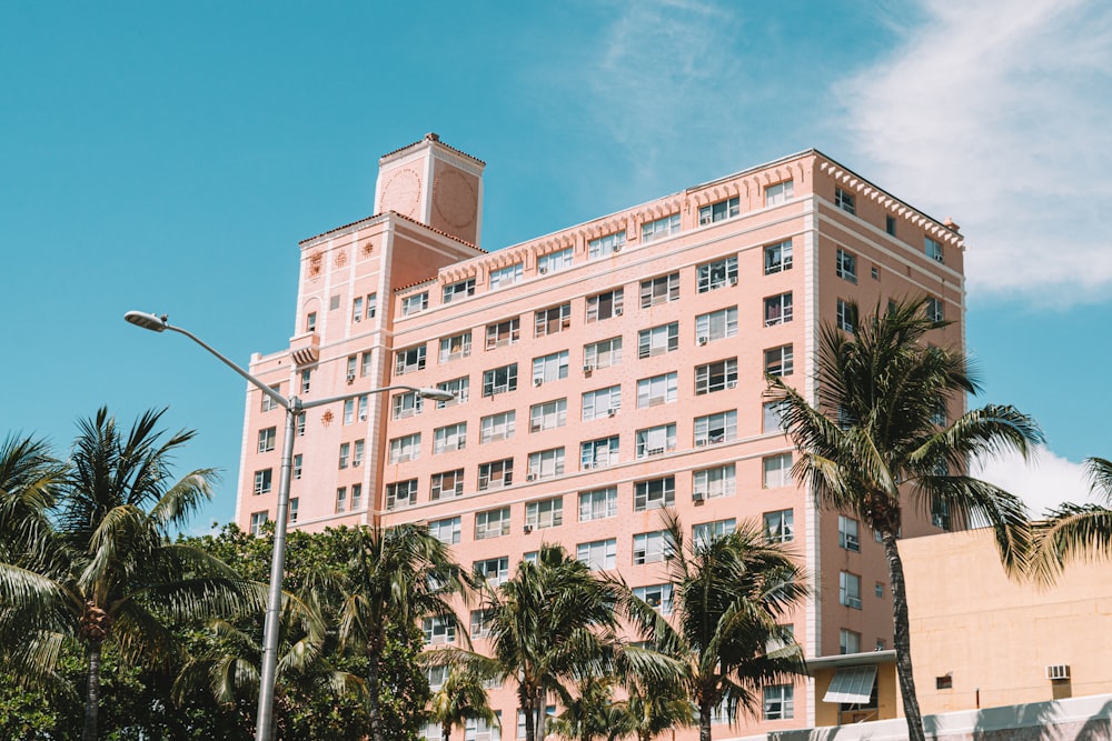 white concrete building near palm trees during daytime