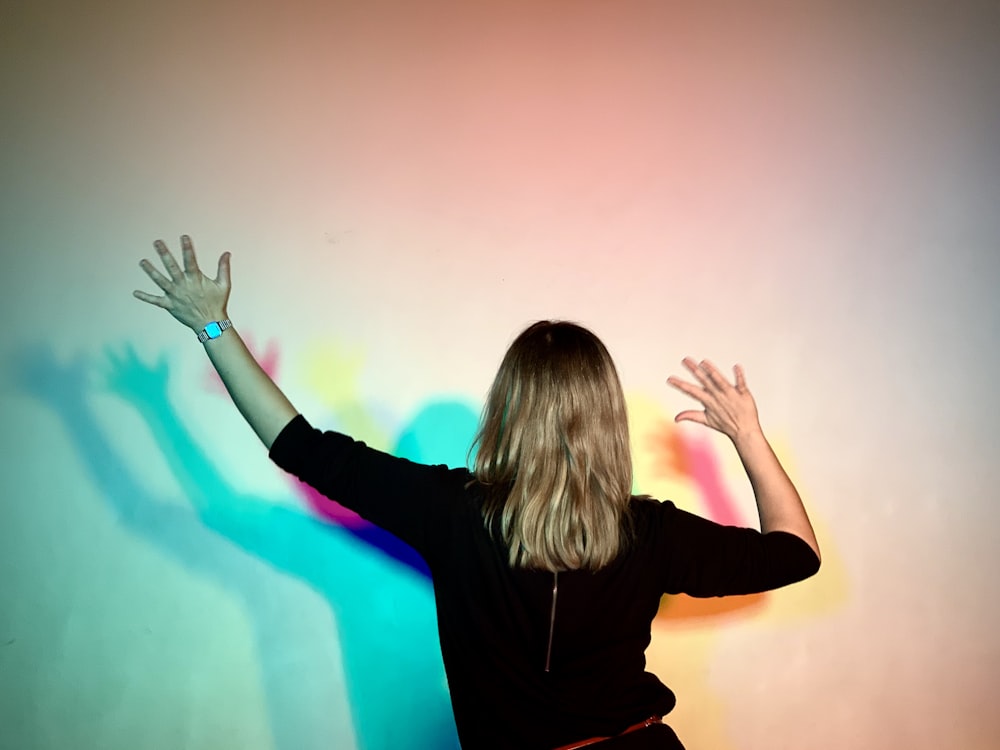 woman in black long sleeve shirt raising her hands