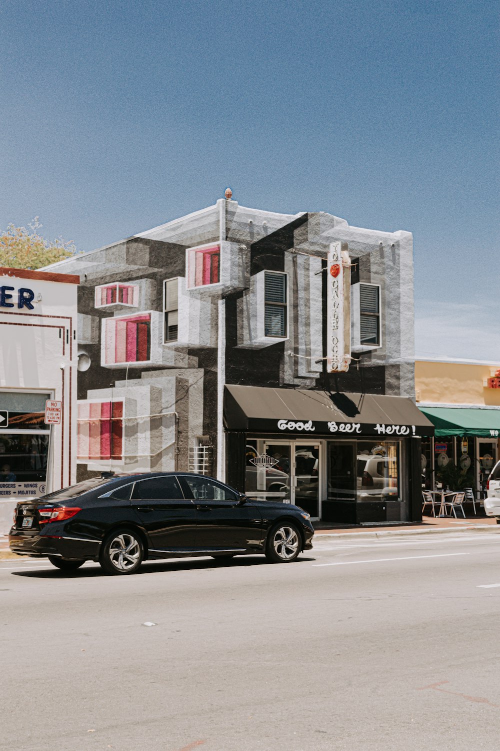 black sedan parked in front of store during daytime