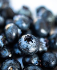 A close-up of fresh wild blueberries on a wooden table, showcasing their vibrant color.