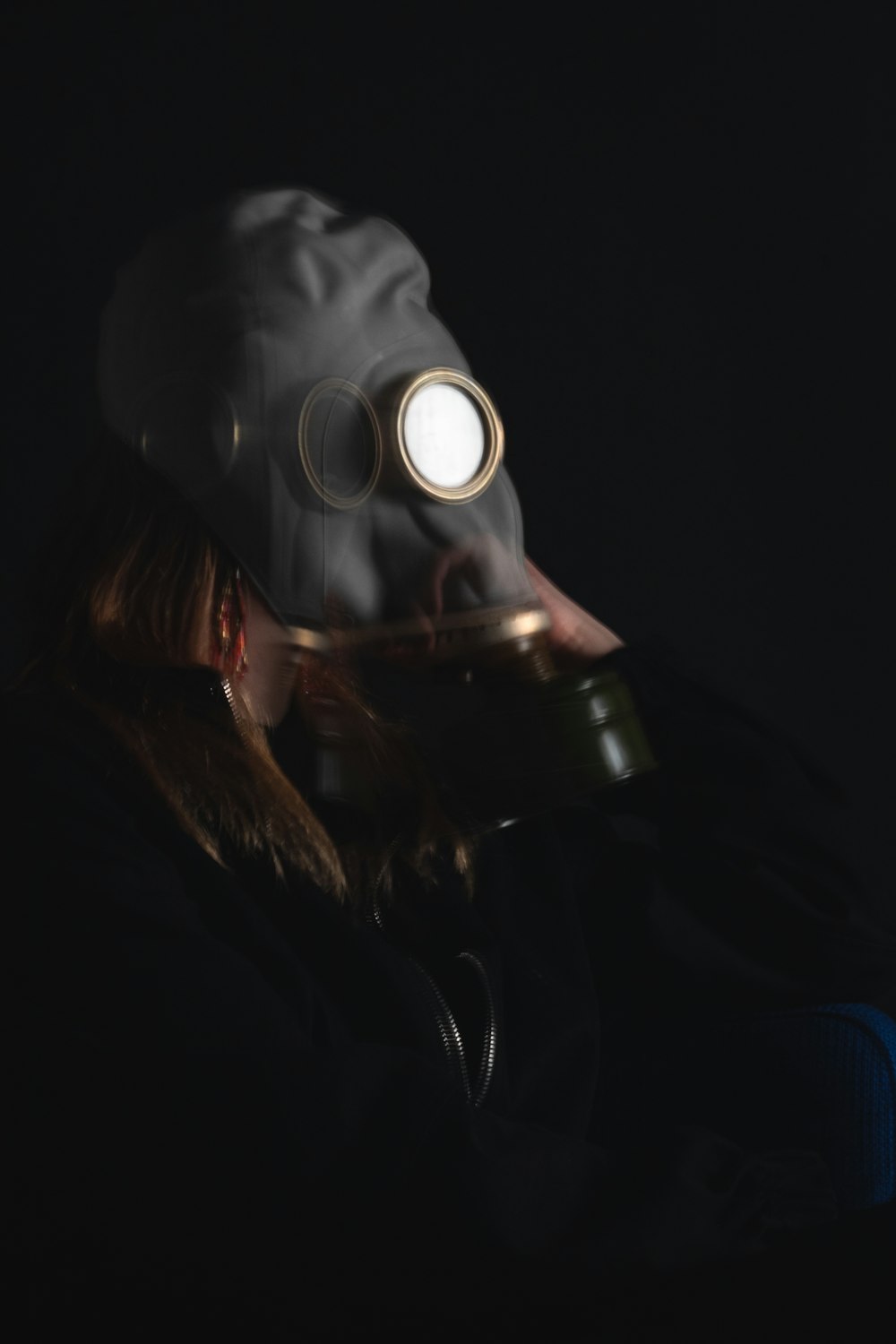 woman in black leather jacket wearing gas mask