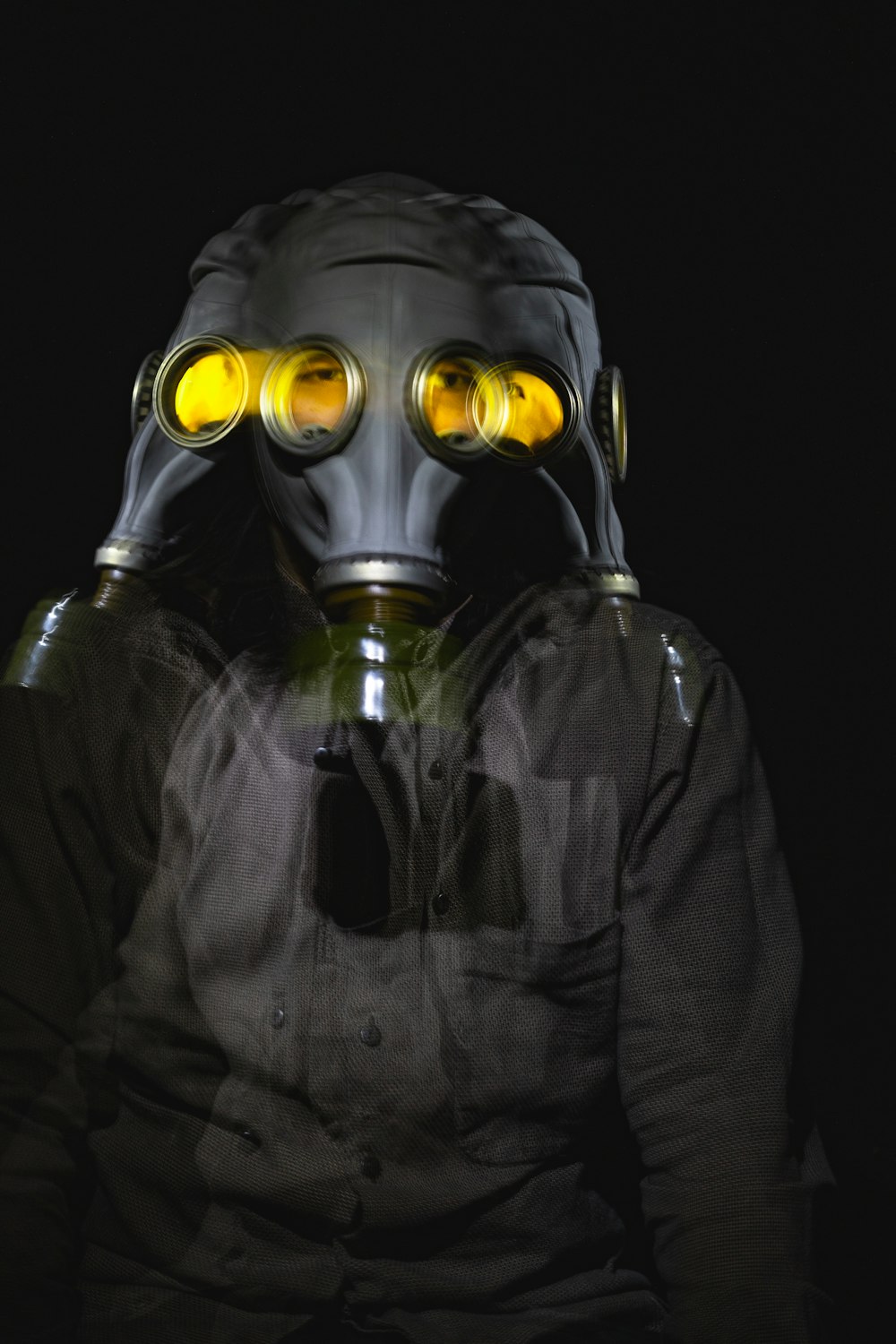 person in black and gray zip up jacket wearing gas mask