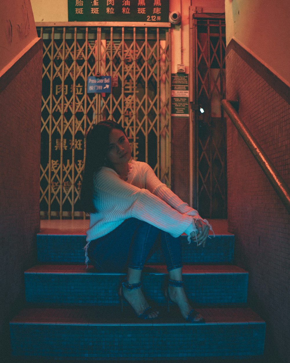 woman in white dress sitting on red staircase