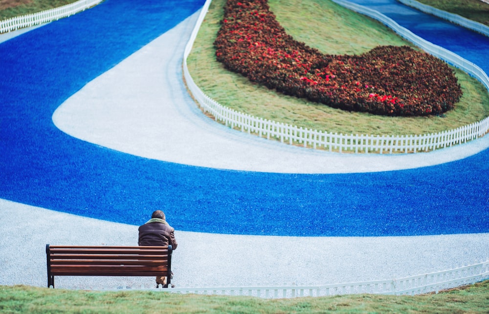 man in brown jacket sitting on bench