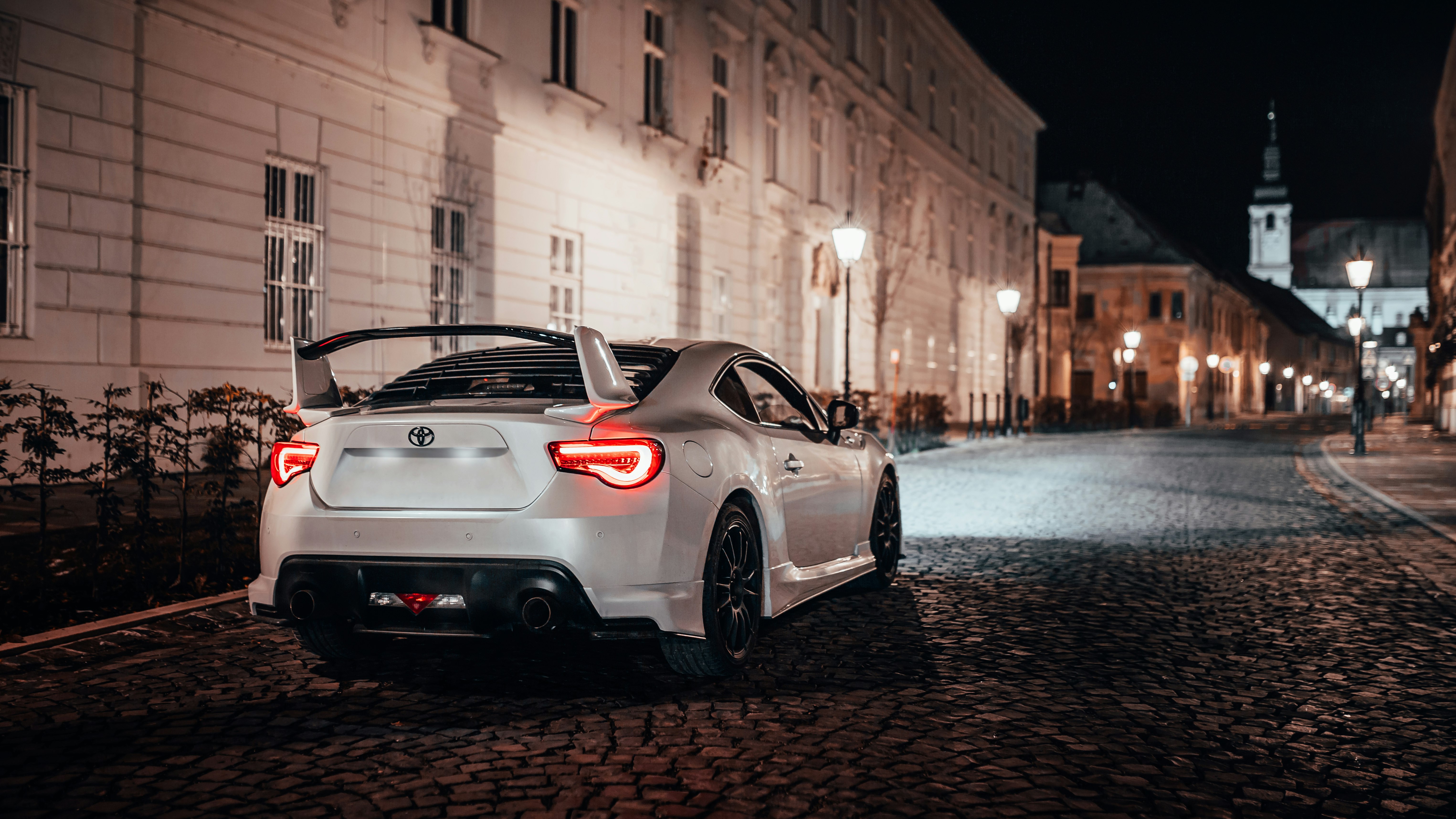 white porsche 911 parked beside road during daytime