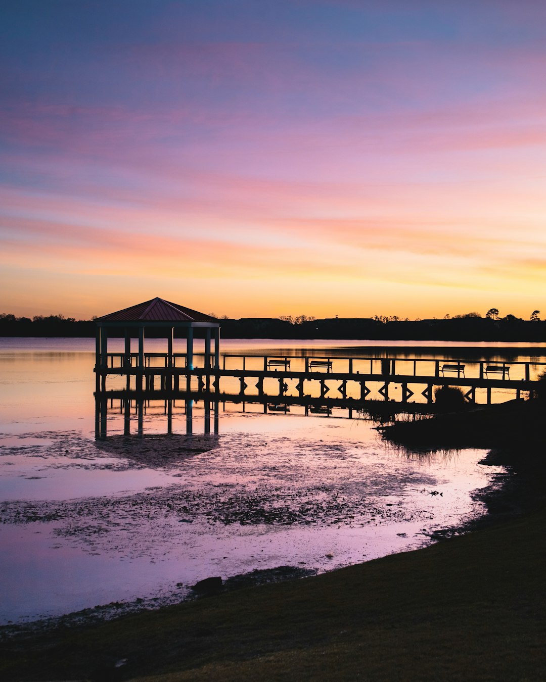 brown wooden house on body of water during sunset