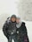 woman in black jacket and gray knit cap standing on snow covered ground during daytime