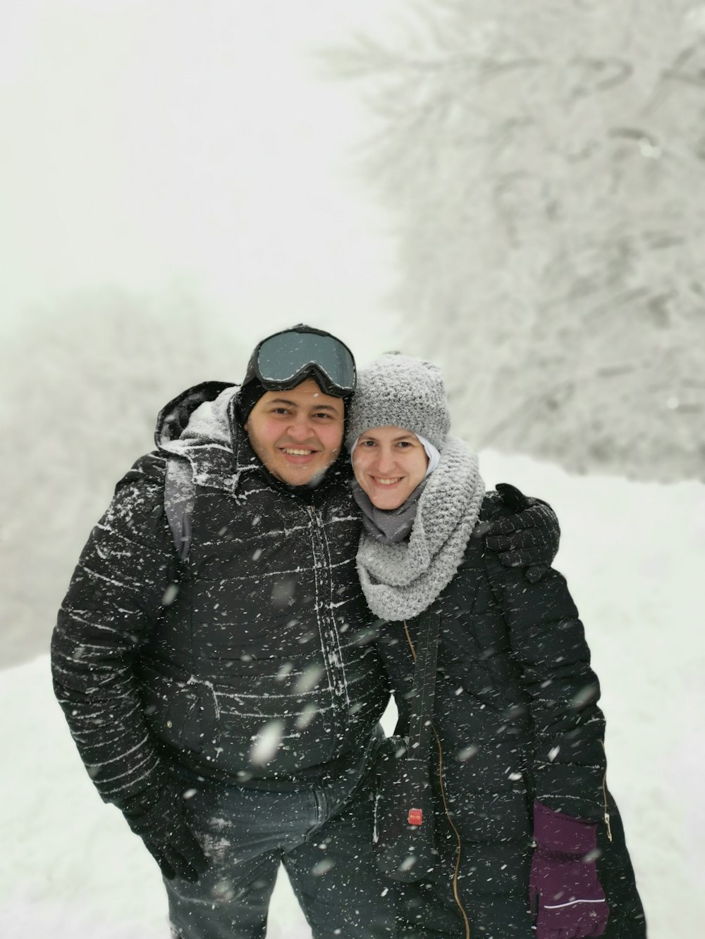 woman in black jacket and gray knit cap standing on snow covered ground during daytime