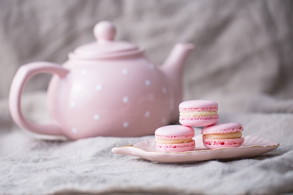 pink and white polka dot ceramic teapot on white textile