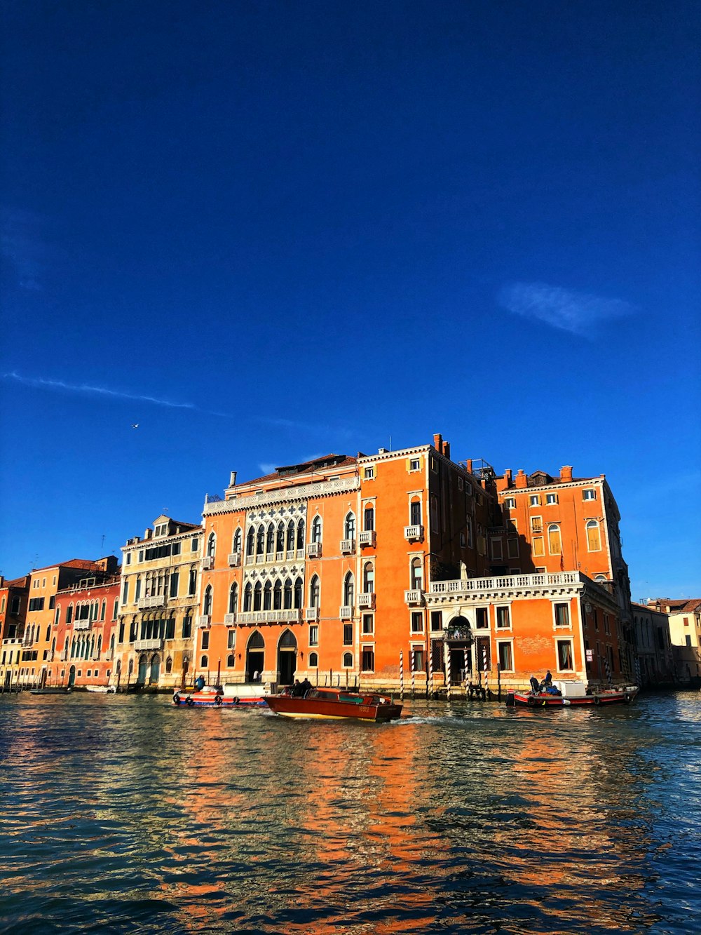 brown concrete building beside body of water during daytime