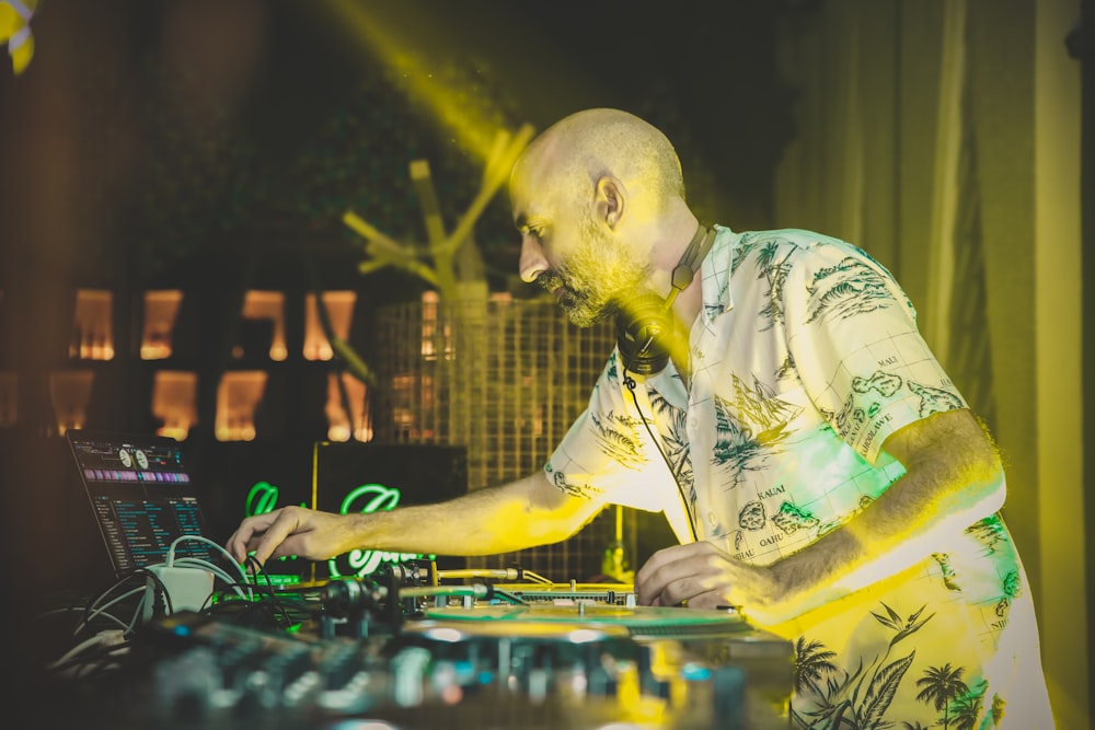 man in yellow and green floral button up shirt playing dj mixer