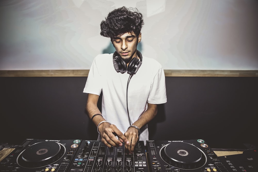 man in white crew neck t-shirt wearing black headphones